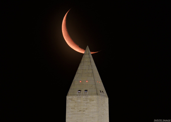 Waning crescent moon rising over the Washington Monument